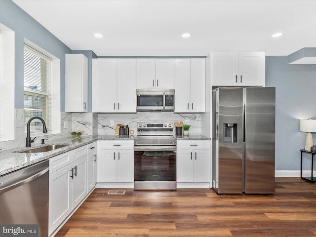 5443 Jonquil Ave, Baltimore, MD 21215 - kitchen featuring stainless steel appliances, a sink, light stone counters, white cabinets, and backsplash
