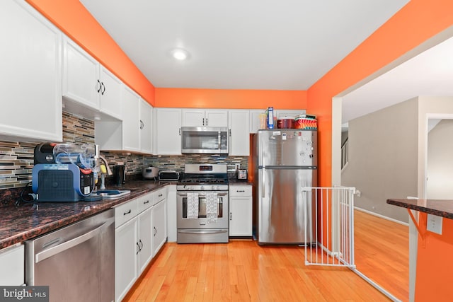 12220 Apple Orchard Ct, Fairfax, VA 22033 - kitchen featuring stainless steel appliances, white cabinetry, light wood finished floors, decorative backsplash, and dark stone countertops