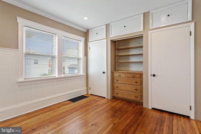 unfurnished bedroom featuring light wood-style flooring and crown molding
