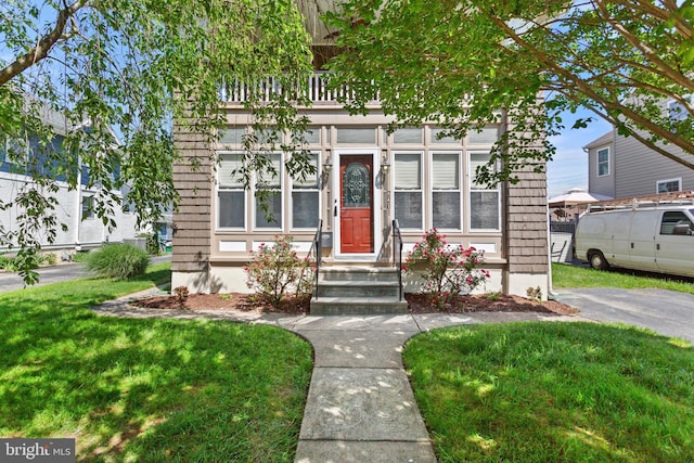 view of front facade featuring a front yard and entry steps