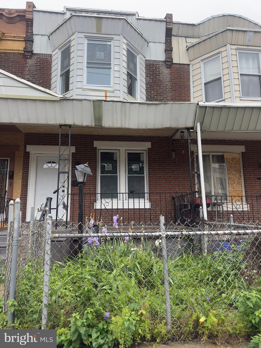 view of front of house featuring a porch and brick siding