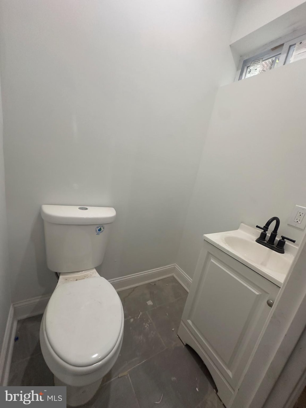 bathroom featuring baseboards, toilet, and vanity