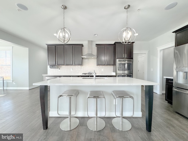 18030 Stump St, Dumfries, VA 22026 - kitchen with appliances with stainless steel finishes, a chandelier, wall chimney range hood, backsplash, and recessed lighting