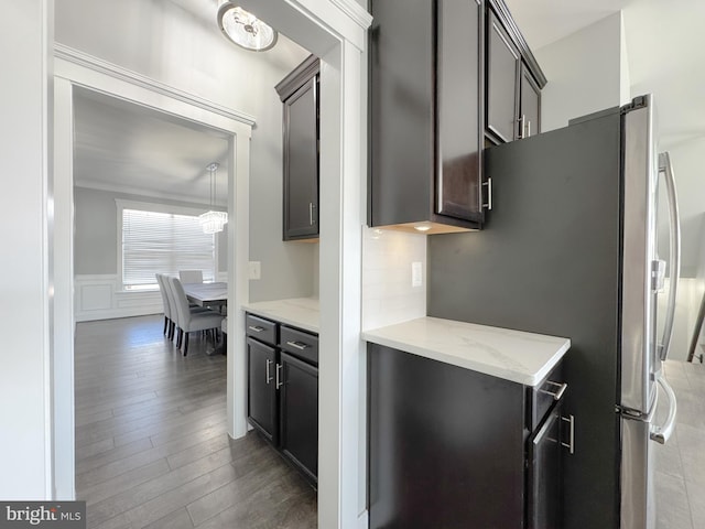 18030 Stump St, Dumfries, VA 22026 - kitchen with wood finished floors, light stone countertops, wainscoting, decorative backsplash, and a decorative wall