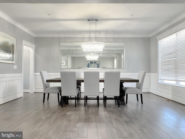 18030 Stump St, Dumfries, VA 22026 - dining space featuring a chandelier, wood finished floors, ornamental molding, wainscoting, and a decorative wall