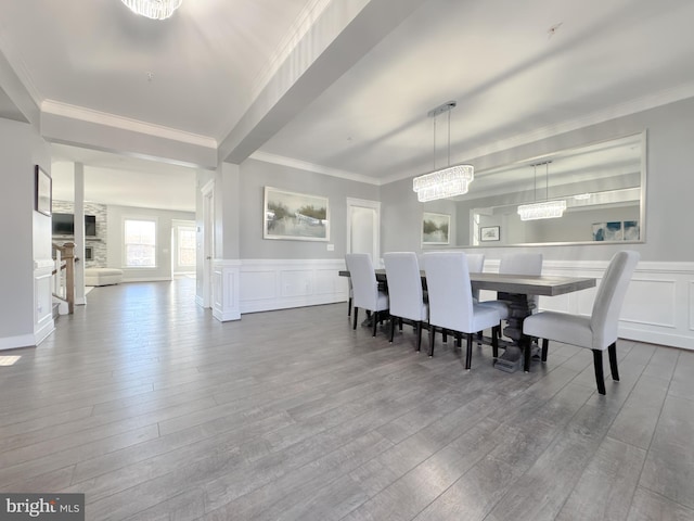 18030 Stump St, Dumfries, VA 22026 - dining area featuring wood finished floors, a decorative wall, crown molding, a wainscoted wall, and a chandelier