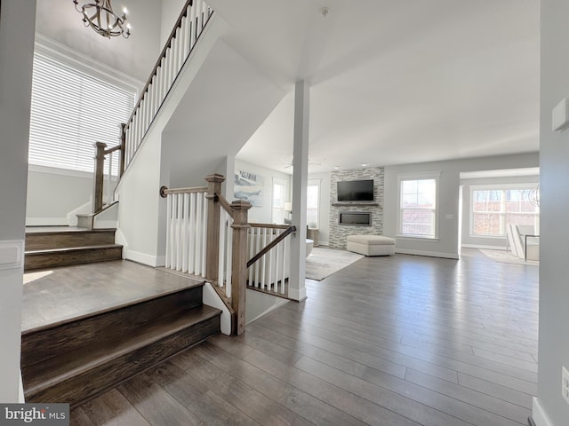 18030 Stump St, Dumfries, VA 22026 - stairs with a stone fireplace, wood finished floors, a chandelier, and baseboards