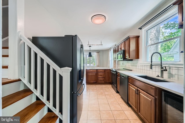 818 Glen Allen Dr, Baltimore, MD 21229 - kitchen featuring wine cooler, black appliances, a sink, light countertops, and tasteful backsplash