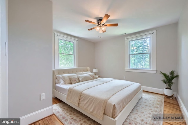 818 Glen Allen Dr, Baltimore, MD 21229 - bedroom featuring multiple windows, baseboards, wood finished floors, and a ceiling fan