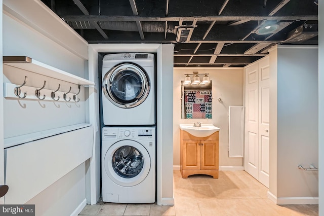 818 Glen Allen Dr, Baltimore, MD 21229 - laundry area featuring stacked washer and clothes dryer, light tile patterned floors, and baseboards