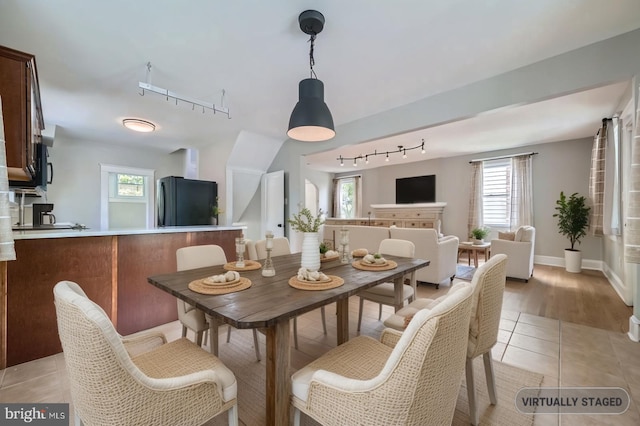 818 Glen Allen Dr, Baltimore, MD 21229 - dining room with rail lighting, light tile patterned floors, and baseboards