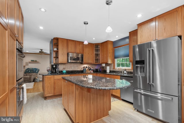 3 Franklin St, Stafford, VA 22556 - kitchen featuring stainless steel appliances, light wood-type flooring, a kitchen island, a sink, and dark stone countertops