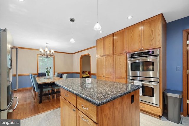 3 Franklin St, Stafford, VA 22556 - kitchen featuring appliances with stainless steel finishes, a kitchen island, arched walkways, a chandelier, and decorative light fixtures