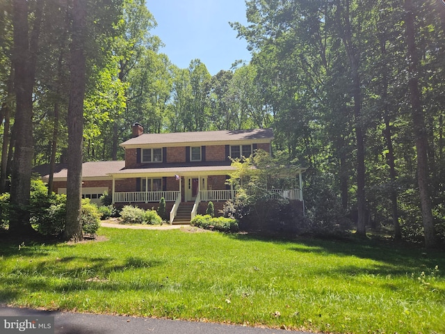 3 Franklin St, Stafford, VA 22556 - colonial-style house with covered porch, a garage, a chimney, a front lawn, and brick siding