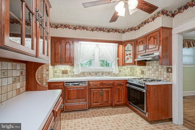 27 N Warren St, Woodbury, NJ 08096 - kitchen with under cabinet range hood, stainless steel range with gas stovetop, dishwasher, light countertops, and a sink