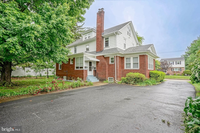 27 N Warren St, Woodbury, NJ 08096 - view of front facade featuring brick siding, entry steps, a chimney, a shingled roof, and driveway