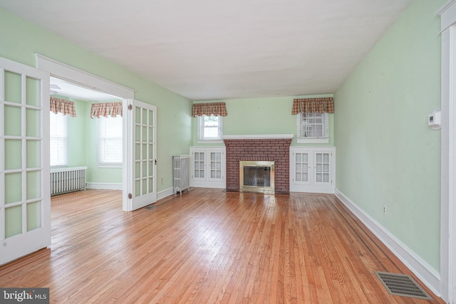27 N Warren St, Woodbury, NJ 08096 - unfurnished living room with light wood-style flooring, radiator heating unit, french doors, and baseboards