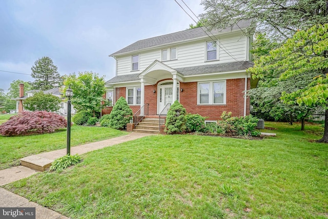 27 N Warren St, Woodbury, NJ 08096 - traditional-style house with brick siding, a front lawn, roof with shingles, and central AC