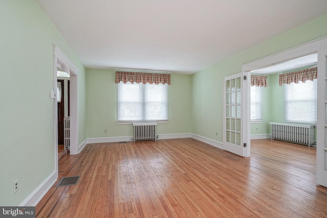 27 N Warren St, Woodbury, NJ 08096 - empty room with radiator, wood finished floors, and plenty of natural light