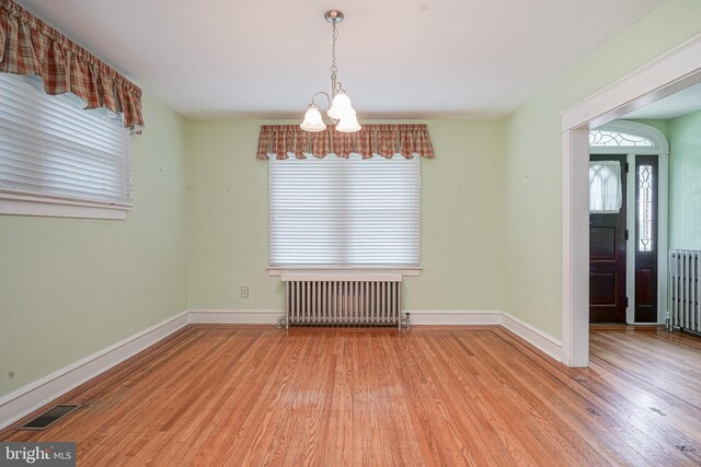 27 N Warren St, Woodbury, NJ 08096 - unfurnished dining area featuring radiator heating unit, a chandelier, wood finished floors, and healthy amount of natural light