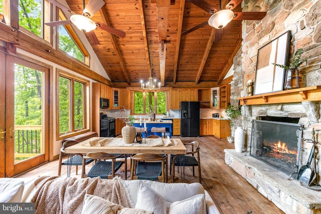 14854 Trout School Rd, Felton, PA 17322 - living area featuring a ceiling fan, high vaulted ceiling, wood ceiling with exposed beams, a stone fireplace, and light wood finished floors