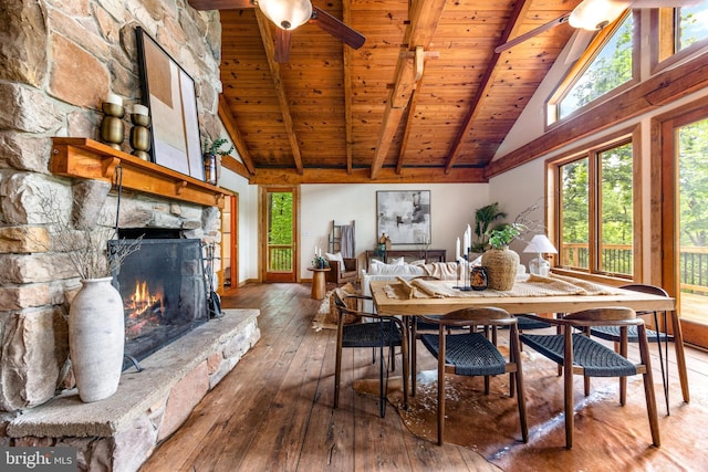 14854 Trout School Rd, Felton, PA 17322 - dining area with wood-type flooring, high vaulted ceiling, wood ceiling with exposed beams, a stone fireplace, and ceiling fan