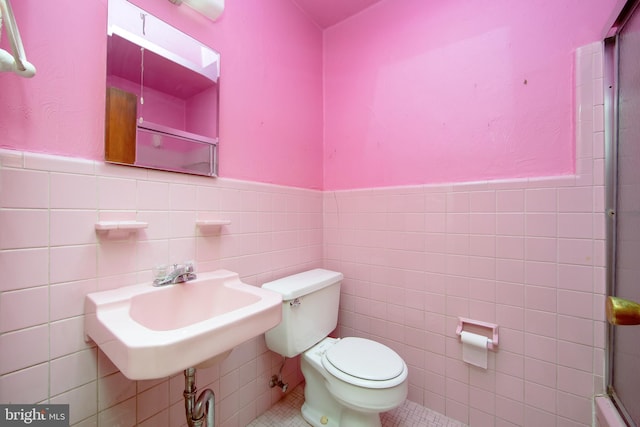 4021 Balwynne Park Rd, Philadelphia, PA 19131 - bathroom featuring tile walls, tile patterned floors, toilet, wainscoting, and a shower with shower door