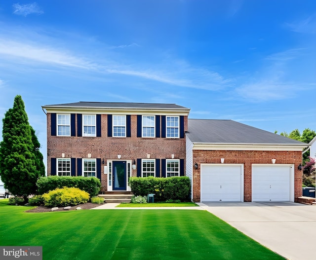 903 Manor House Dr, Upper Marlboro, MD 20774 - colonial home featuring an attached garage, a front yard, brick siding, and concrete driveway