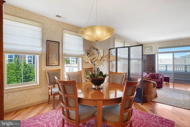 440 Belmont Bay Dr Unit 406, Woodbridge, VA 22191 - dining area featuring wood finished floors, wallpapered walls, and baseboards