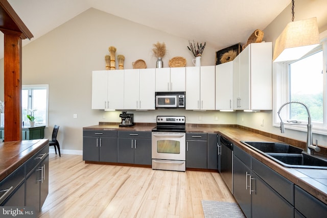 311 Summit Woods Dr, Mc Henry, MD 21541 - kitchen with stainless steel appliances, a sink, white cabinetry, light wood-type flooring, and high vaulted ceiling