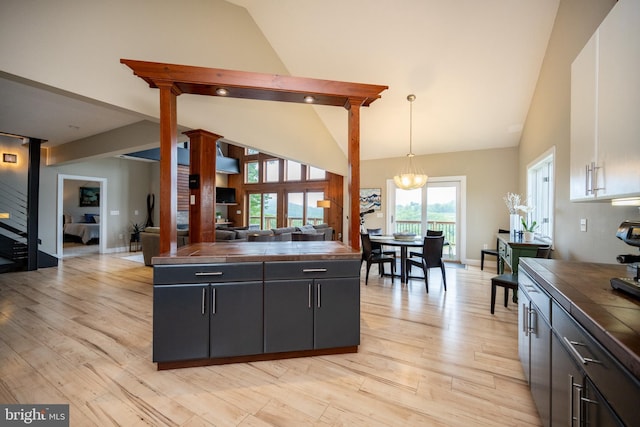 311 Summit Woods Dr, Mc Henry, MD 21541 - kitchen featuring tile countertops, light wood-style flooring, open floor plan, pendant lighting, and high vaulted ceiling
