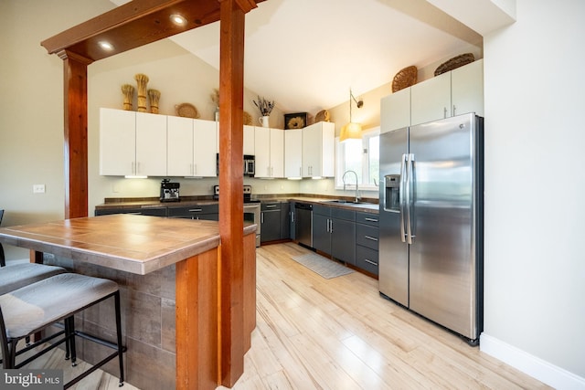 311 Summit Woods Dr, Mc Henry, MD 21541 - kitchen with appliances with stainless steel finishes, a sink, a kitchen breakfast bar, white cabinets, and light wood finished floors