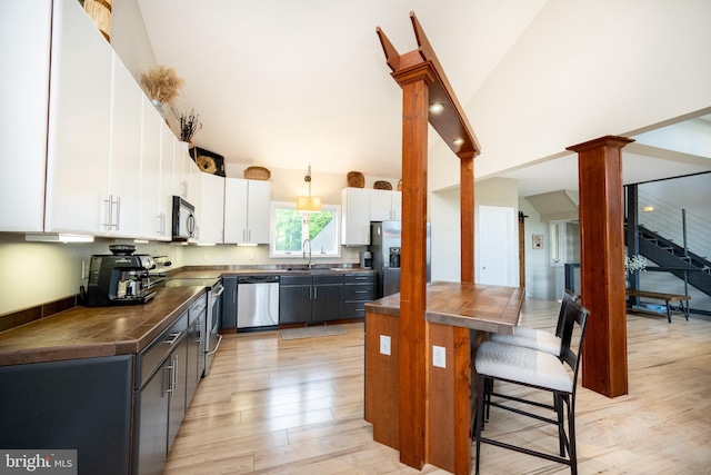 311 Summit Woods Dr, Mc Henry, MD 21541 - kitchen with stainless steel appliances, dark countertops, a sink, a breakfast bar, and light wood finished floors