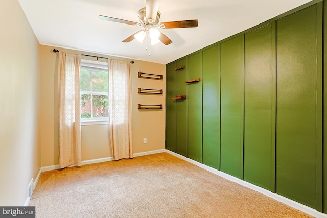 unfurnished room featuring ceiling fan, light colored carpet, and baseboards