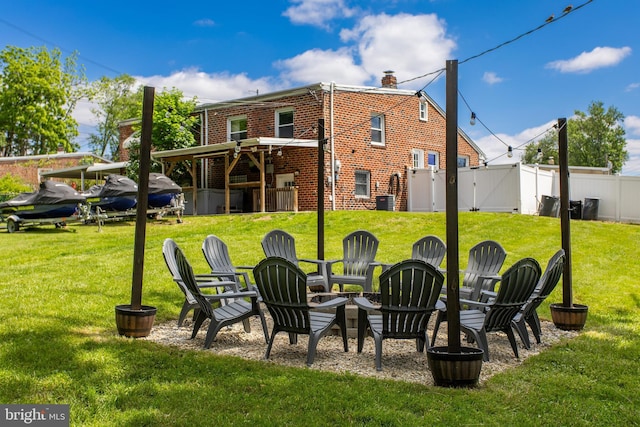 rear view of property with a gate, an outdoor fire pit, brick siding, and a chimney