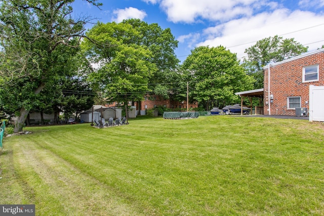 view of green lawn with central AC unit