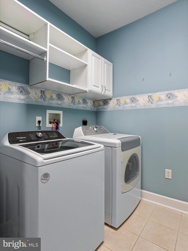 12953 Little Hayden Cir, Hagerstown, MD 21742 - laundry area featuring cabinet space, washing machine and clothes dryer, light tile patterned floors, and baseboards