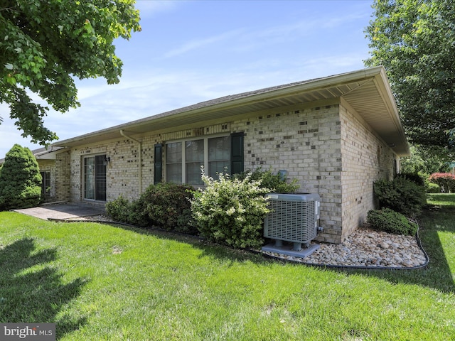 12953 Little Hayden Cir, Hagerstown, MD 21742 - view of side of property featuring central air condition unit, a yard, and brick siding