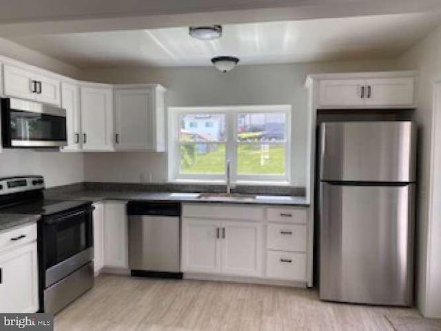 70 Chestnut St, Mohnton, PA 19540 - kitchen featuring appliances with stainless steel finishes, a sink, white cabinets, and light wood-style flooring