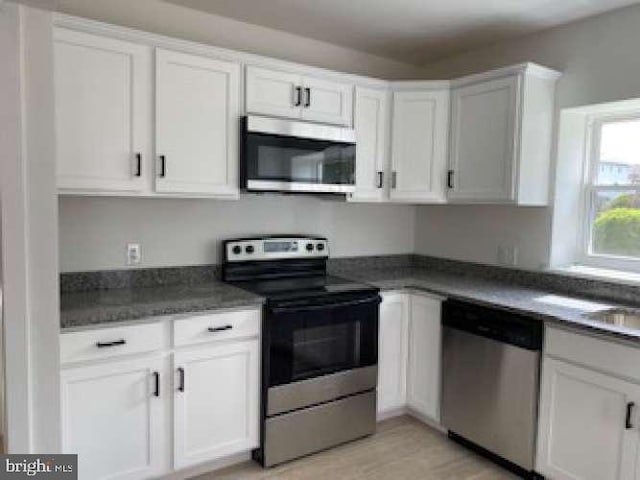 70 Chestnut St, Mohnton, PA 19540 - kitchen featuring appliances with stainless steel finishes, white cabinetry, dark countertops, and light wood-style floors