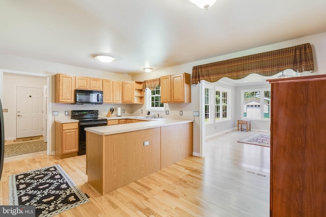 14323 Shiloh Church Rd, Laurel, DE 19956 - kitchen featuring black appliances, light countertops, light wood-style floors, a peninsula, and light brown cabinets