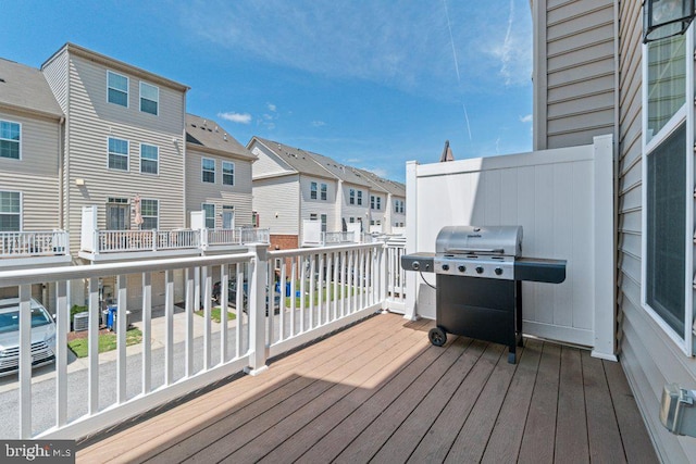 wooden terrace with a residential view and a grill