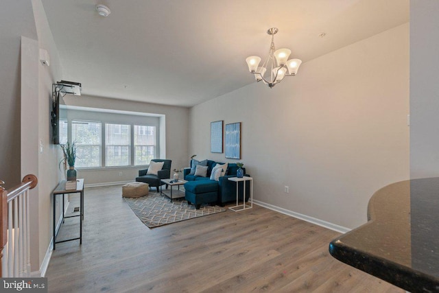 sitting room with a chandelier, wood finished floors, and baseboards