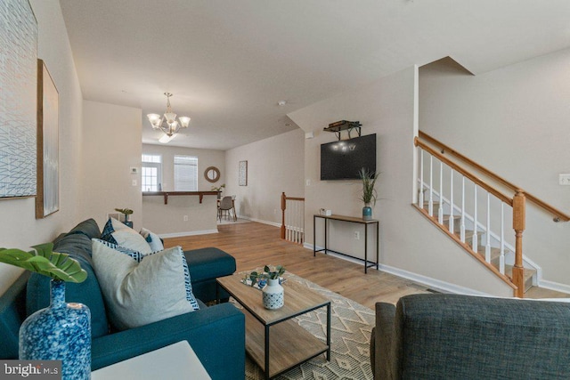 living room with wood finished floors, a chandelier, and baseboards