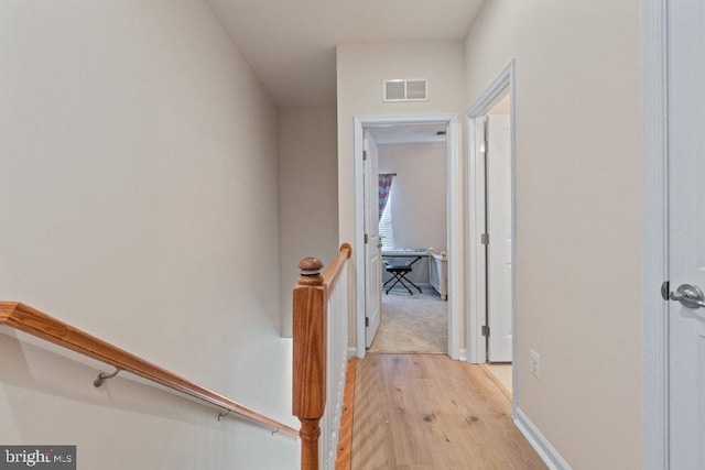 hall with light wood-type flooring and baseboards