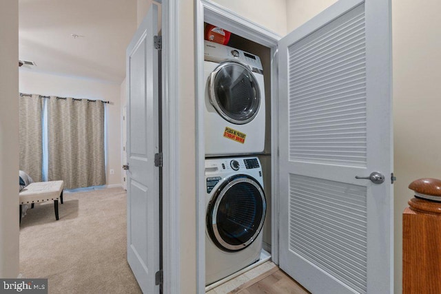 washroom featuring estacked washer and dryer and carpet flooring
