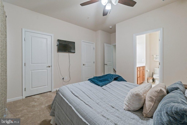 bedroom with light colored carpet, connected bathroom, baseboards, and a ceiling fan