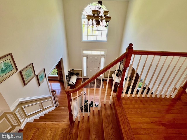 4718 Village Dr, Fairfax, VA 22030 - staircase with a high ceiling, wood finished floors, a chandelier, and plenty of natural light