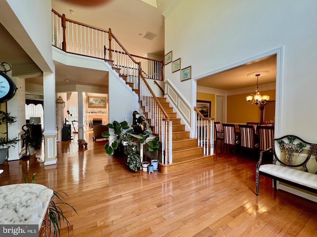 4718 Village Dr, Fairfax, VA 22030 - foyer entrance with a towering ceiling, a chandelier, stairway, wood-type flooring, and a fireplace