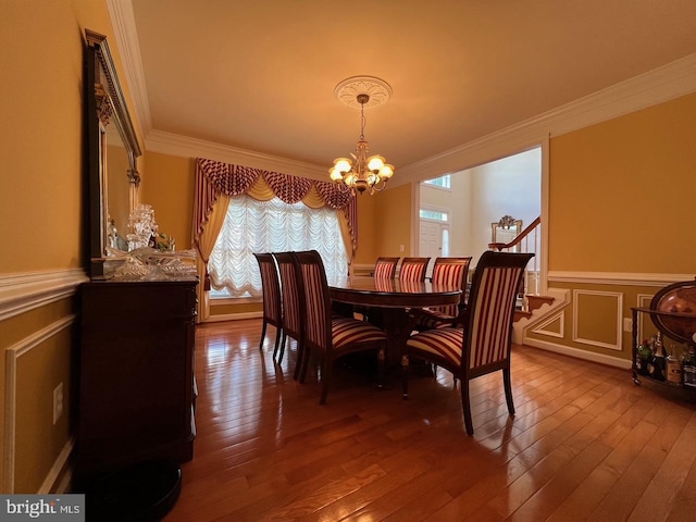 4718 Village Dr, Fairfax, VA 22030 - dining space featuring a chandelier, crown molding, dark wood-type flooring, wainscoting, and a decorative wall